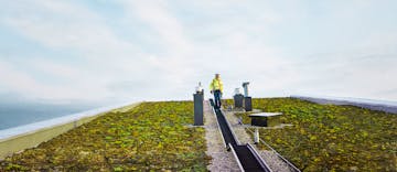 Kasvillisuuden peittämällä katolla huoltohenkilö