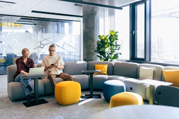 Kollegat tutkivat papereita ja tietokoneen ruutua toimistolla