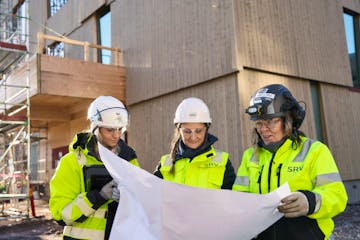 Rakentajat tutkivat suunnitelmia työmaalla