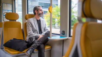 Työntekijä matkalla töihin raitiovaunulla